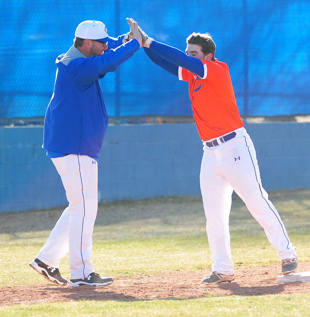 Chino Valley's Michael Paulus celebrates his triple with Head Coach Mark Middleton as the Cougars play the Snowflake Lobos to open the 2018 baseball season Thursday afternoon in Chino Valley. (Les Stukenberg/Courier)