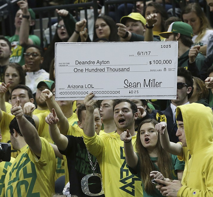 Fans in the Oregon student section hold up a sign making fun of the controversy surrounding Arizona coach Sean Miller, during the first half Saturday, Feb. 24, 2018, in Eugene, Ore. (Chris Pietsch/AP)
