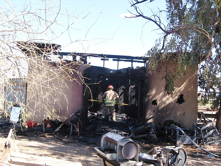 A firefighter steps into the aftermath of a shed that was completely destroyed by a fire Sunday, March 4, 2018, in Congress. (YSCO/Courtesy)