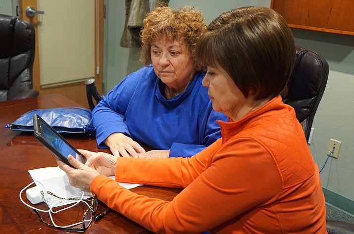 Prescott resident Vera Dicicco, left, listens as Prescott Public Library volunteer Paula Williams describes the features of an iPad equipped with assistive technology apps for the vision impaired. The tablet is available through a new program at the library -- You Too! Community Access and Engagement through Assistive Technology. (Cindy Barks/Courier)