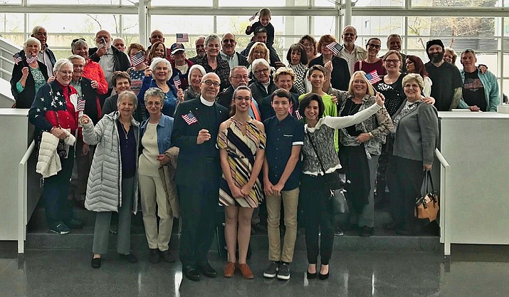 In this photo – taken at the Sandra Day O’Connor U.S. Courthouse in Phoenix on Friday, Feb. 16, 2018 – Fr. Pierre-Henry Buisson, rector of Saint Luke’s Episcopal Church of Prescott, stands in the front row with his family – daughter Pauline, son Clement and wife Sophie – after the French family became U.S. citizens. They were accompanied at the ceremony by several dozen cheering members of the Saint Luke’s congregation. (Courtesy)
