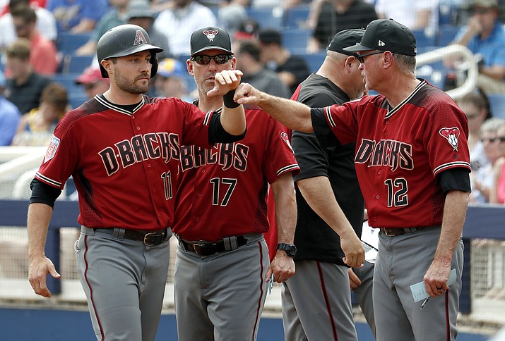 Arizona Diamondbacks’ A.J. Pollock (11) is greeted by bench coach Jerry Narron (12) after scoring on a sacrifice fly by Jake Lamb during the first inning of a spring training baseball game against the Milwaukee Brewers on Thursday, March 8, 2018, in Phoenix. (Matt York/AP)