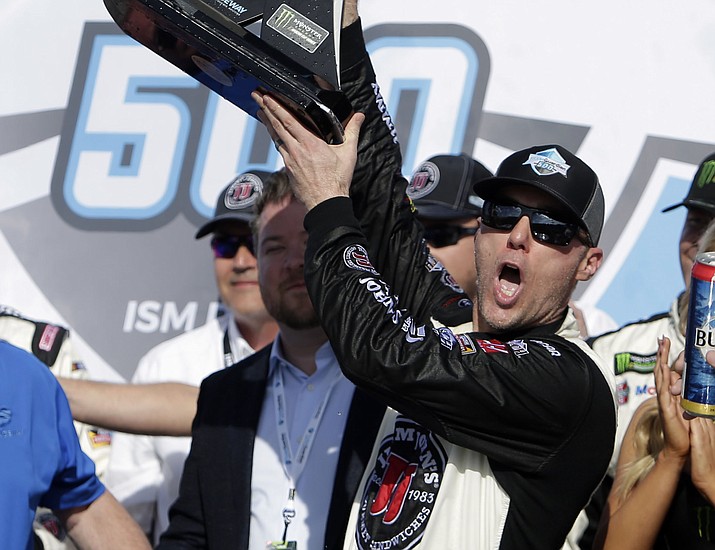 Kevin Harvick holds up the trophy after winning a NASCAR Cup Series auto race on Sunday, March 11, 2018, in Avondale. (Rick Scuteri/AP)