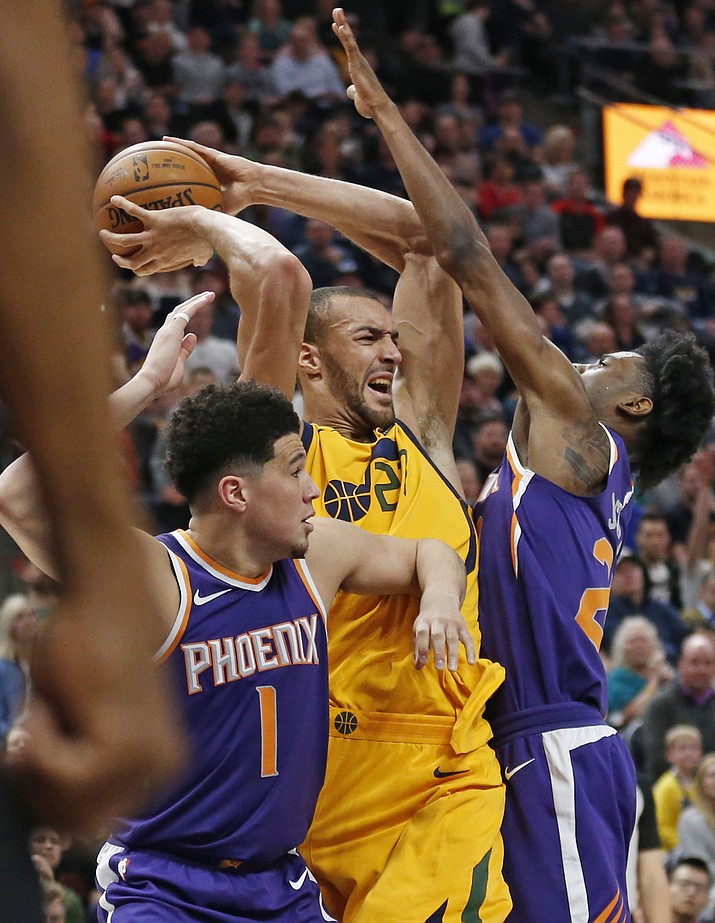 Phoenix Suns’ Josh Jackson, right, and Devin Booker (1) defend against Utah Jazz center Rudy Gobert, center, during the first half of an NBA basketball game Thursday, March 15, 2018, in Salt Lake City. 
