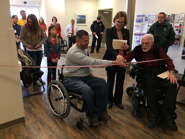Eriberto “Eddie” Alvarez, left, — with wife, Stacie, and daughter, Grace, 9, standing behind — cuts the ribbon along with Veterans Affairs Medical Center Director Barbara Oemcke and fellow U.S. Army veteran Ken Briefer. (Nanci Hutson/Courier)