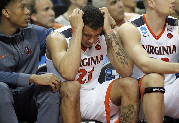 Virginia's Isaiah Wilkins (21) is consoled after fouling out during the second half of the team's first-round game against UMBC in the NCAA men's college basketball tournament in Charlotte, N.C., Friday, March 16, 2018.