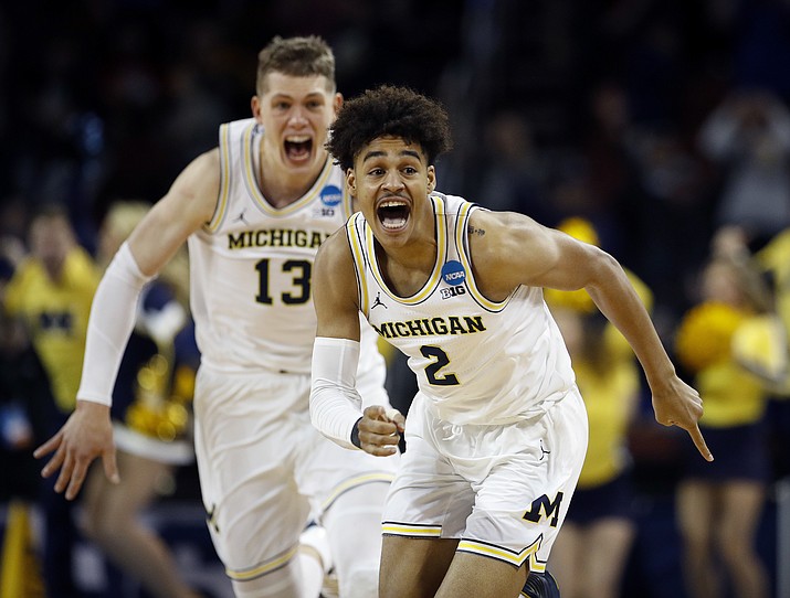 Michigan guard Jordan Poole (2) is chased by forward Moritz Wagner (13) after making a 3-point basket at the buzzer to beat Houston on Saturday, March 17, 2018, in Wichita, Kan. Michigan won 64-63. (Charlie Riedel/AP)