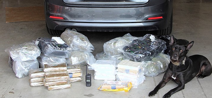 Yavapai County Sheriff’s Office K9, Vader sits with nearly $1 million worth of drugs after a deputy made a traffic stop for an equipment violation March 12, near Ash Fork. After Vader completed an external sniff of the vehicle and alerted the deputy, 47.5 pounds of cocaine and 27.5 pounds of marijuana were discovered. (YCSO/Courtesy)
