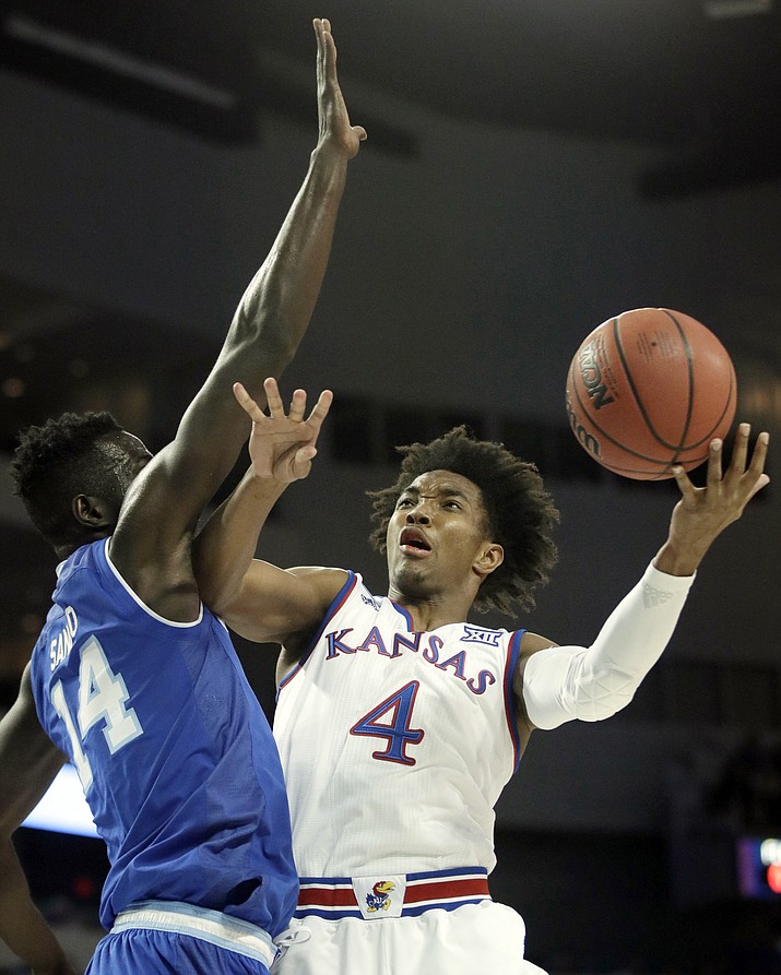 In this Saturday, March 17, 2018, file photo, Kansas guard Devonte' Graham (4) shoots while covered by Seton Hall forward Ismael Sanogo (14) during the first half of an NCAA men's college basketball tournament second-round game in Wichita, Kan. Kansas takes on Clemson in a regional semifinal on Friday. (AP Photo/Orlin Wagner, File)

