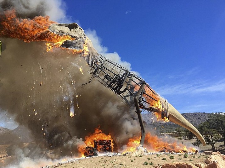 In a Thursday, March 22, 2018 photo provided by the Royal Gorge Dinosaur Experience, a life-sized animatronic Tyrannosaurus Rex at the Royal Gorge Dinosaur Experience in Canon City, Colo., is ablaze after an electrical issue, according to Royal Gorge Dinosaur Experience personnel. T-Rex was a total loss, but Zach Reynolds, co-owner of Royal Gorge Dinosaur Experience, hopes to have a replacement T-Rex before summer. (Royal Gorge Dinosaur Experience via AP)

