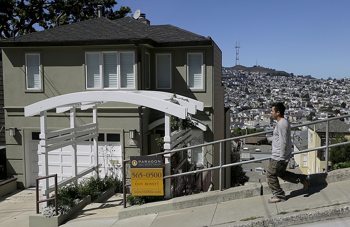 In this March 17, 2014, file photo, a man walks past a home for sale in San Francisco. A house with a fabulous view can be hard for a homebuyer to resist. (Jeff Chiu, AP)
