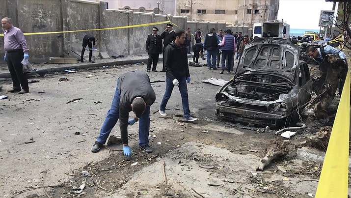 Security members search the area after a bomb placed under a nearby car exploded Saturday, March 24, 2018 in Alexandria, Egypt, as the city security chief's convoy passed by, killing at least one policeman and wounding four others, the Interior Ministry said. Local media reports said Gen. Mostafa al-Nimr survived the explosion and he was seen on a local TV channel in good condition while inspecting the area of the blast shortly after it took place. No group immediately claimed responsibility for the explosion, which happened in the vicinity of a police station in the central district of Roshdi. (AP Photo/Mohamed Khalil)

