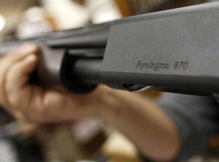 In this March 1, 2018, file photo the Remington name is seen etched on a model 870 shotgun at Duke's Sport Shop in New Castle, Pa. U.S. gun maker Remington Outdoor Company filed for bankruptcy protection, after years of falling sales and lawsuits tied to the Sandy Hook Elementary School massacre. Records from the bankruptcy court of the district of Delaware show that the company filed late Sunday, March 25. (AP Photo/Keith Srakocic, File)