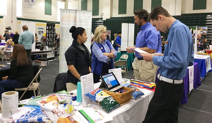 Vinson White, right, of Dewey-Humboldt, looks over material about Printpack with the company’s staff, from left, Iveth Castro, human resources manager Diana Buchanan, and Jason Whitten at the Job and Career Fair at Yavapai College Friday, March 23. (Sue Tone/Courier)
