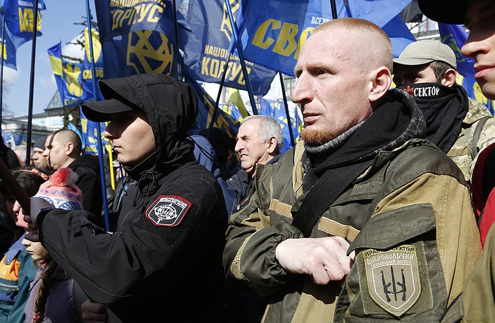 Ultra-right activists hold their party flags as they attend a rally against tycoons in national politics and economy in central Kiev, Ukraine, Tuesday, April 3, 2018. For decades after World War II, racist, extremist and anti-Semitic views were considered taboo in public life, strictly confined to the far-right fringes. Today they are openly expressed by mainstream political leaders in parts of Central and Eastern Europe, part of a global populist surge in the face of globalization and mass migration. (AP Photo/Efrem Lukatsky)

