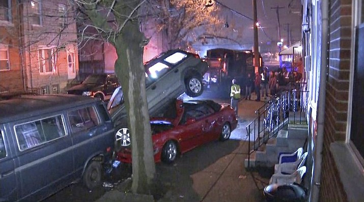 This still image taken from video shows vehicles damaged by an out-of-control trash truck on Wednesday, April 4, 2018, in Philadelphia. The out-of-control trash truck smashed into a row of parked cars along a residential street in Philadelphia, but no injuries have been reported. (Kyle Hall/CBS3 via AP)

