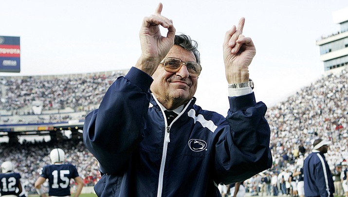 In this Nov. 5, 2005, file photo, Penn State football coach Joe Paterno acknowledges the crowd during warm-ups before an NCAA college football game against Wisconsin in State College, Pa. “Paterno” aims to tell the polarizing story of a legend’s fall, when the most essential question can never be answered. The HBO movie directed by Barry Levinson debuts April 7 and stars Oscar winner Al Pacino as Joe Paterno, the Penn State coach whose career ended in scandal. (AP Photo/Carolyn Kaster, File)


