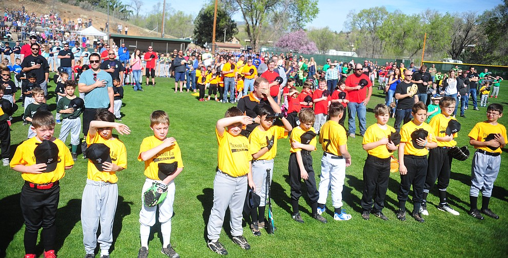 Players honor the flag as the National Anthem is sung during opening ceremonies for the 2018 Prescott Little League Saturday, April 7, 2018 at Bill Vallely Field in Prescott. (Les Stukenberg/Courier)