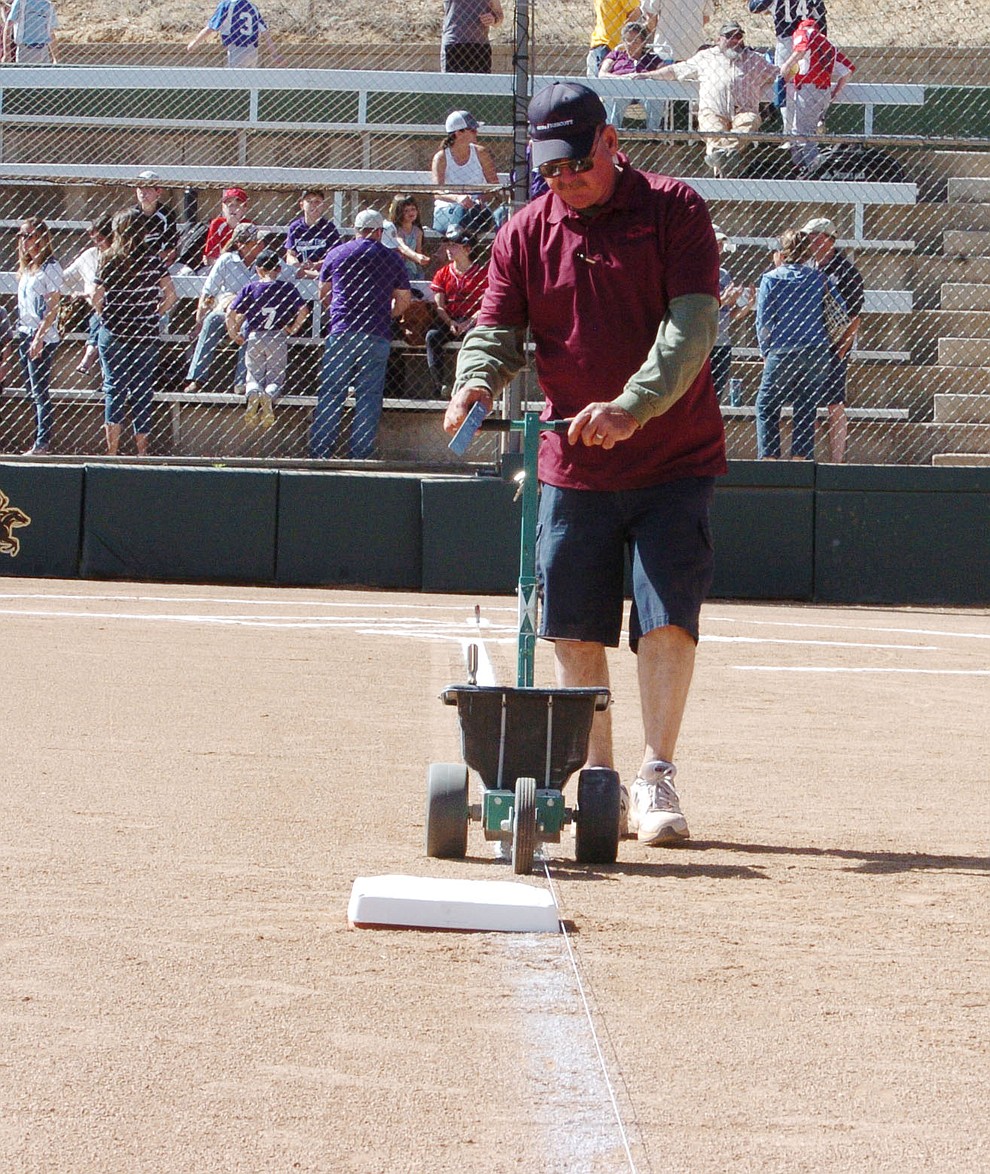 Bill Vallely relines the field, named after his father, following the opening ceremonies for the 2018 Prescott Little League Saturday, April 7, 2018 at Bill Vallely Field in Prescott. (Les Stukenberg/Courier)