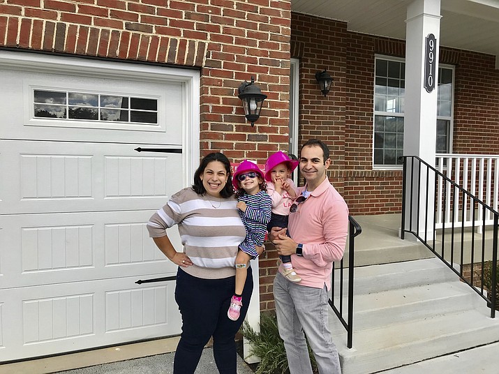 From left, Allison, Abigail, Isabel and Matt Weil are pictured in this undated photo in front of a their new home in Laurel, Maryland. The Weils have twice used mortgage loans from Matt’s parents to buy a home. (Nerdwallet via AP)
