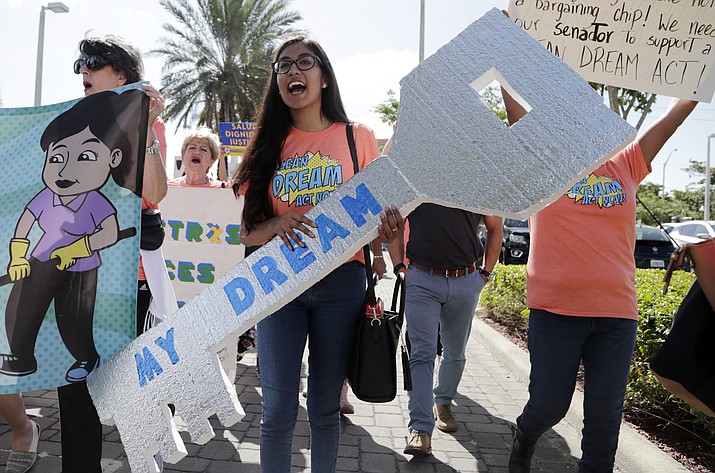 Maria Angelica Ramirez carries a large key reading "My Dream" during a protest outside the office of Sen. Marco Rubio, R-Fla., in support of Deferred Action for Childhood Arrivals (DACA), and Congress passing a clean Dream Act, Monday, Jan. 22, 2018, in Doral, Fla. (AP Photo/Lynne Sladky)
