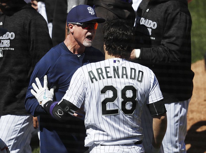San Diego Padres bench coach Mark McGwire, left, restrains Colorado Rockies' Nolan Arenado after he charged the mound following getting hit by a pitch from Padres starting pitcher Luis Perdomo in the third inning of a baseball game Wednesday, April 11, 2018, in Denver. (David Zalubowski/AP)