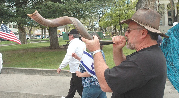 Mark Juarez blows a Shofar while walking around courthouse plaza during the March of Remembrance Sunday, April 15. (Jason Wheeler/Courier)