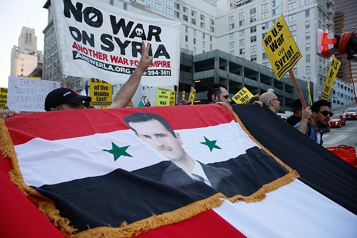 Syrian-Americans express their anger at the missile strikes on their homeland during an anti-war rally opposing the military strikes by Western countries in Syria, in downtown Los Angeles, Saturday, April 14, 2018. On Saturday, those commemorating Syria's independence from France in 1946, called the missile strikes by the U.S., Britain and France illegal. (AP Photo/Damian Dovarganes)

