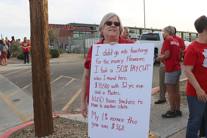 Lee Williams teacher Pam Cochran holds up a sign that summarizes her 32 years of teaching experience and only getting paid $35,500 a year with a master’s degree during a recent walk in. 