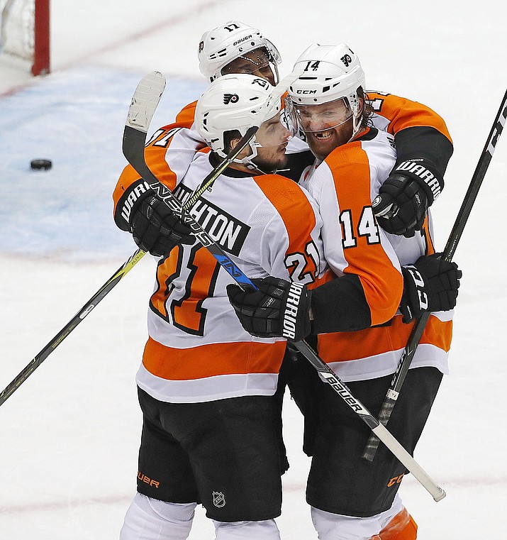 Philadelphia Flyers' Sean Couturier (14) celebrates his goal with Scott Laughton (21) and Wayne Simmonds during the third period in Game 5 of an NHL first-round hockey playoff series against the Pittsburgh Penguins in Pittsburgh, Friday, April 20, 2018. (AP Photo/Gene J. Puskar)