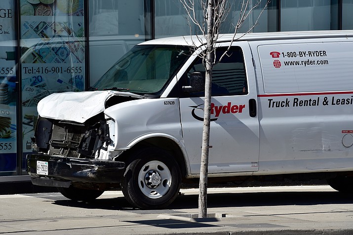 A van with a damaged front-end sits idle on a sidewalk after the driver drove down a sidewalk crashing into a number of pedestrians in Toronto, Monday, April 23, 2018. The van apparently jumped a curb Monday in a busy intersection in Toronto and struck the pedestrians and fled the scene before it was found and the driver was taken into custody, Canadian police said. (Frank Gunn/The Canadian Press via AP)

