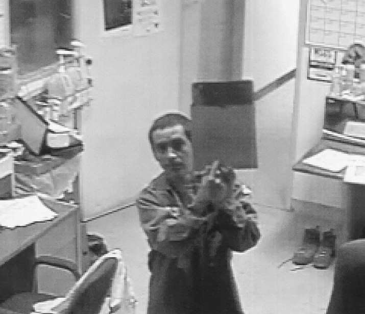 A man suspected of stealing a 2015 Ford F-550 used by the Waste Management Gray Wolf Landfill on Highway 169 is shown on a camera wearing one of the company’s employee uniforms and pointing to a clipboard. (Yavapai County Sheriff’s Office/Courtesy) 