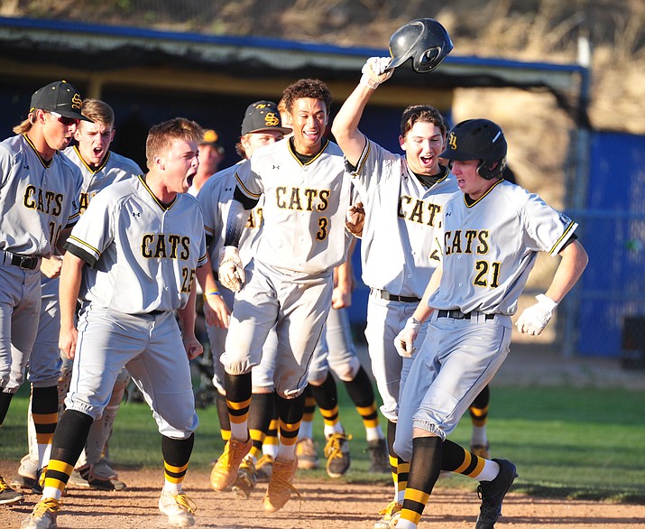 Saguaro players react at home plate after Joel Rubin (21) hit a three-run home run in the top of the seventh inning to give the Sabercats an 8-5 lead during a 4A state play-in game Wednesday, April 25, 2018, in Prescott. Saguaro won 8-5 and advanced to the 4A state playoffs, eliminating Prescott. (Les Stukenberg/Courier)