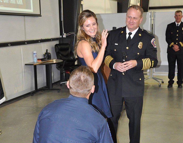 Jaron Kirk (on one knee) proposes to his girlfriend, Carli Gibson, immediately after being promoted to Firefighter Captain during a Central Arizona Fire and Medical Authority (CAFMA) recognition ceremony Thursday evening, April 26. CAFMA Chief Scott Freitag, right, assisted in the planned proposal. (Bill Brookins/Courtesy)