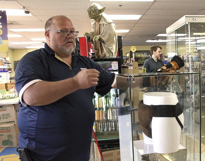 Blockbuster Alaska General Manager Kevin Daymude moves a display case featuring the jockstrap worn by actor Russell Crowe in the 2005 movie “Cinderella Man” at the video store location in Anchorage, Alaska, on Wednesday, May 2, 2018. HBO’s John Oliver bought the jockstrap and other items at auction and sent them to Anchorage, in hopes it would help the store stave off pressure from streaming movie services. (AP Photo/Mark Thiessen)

