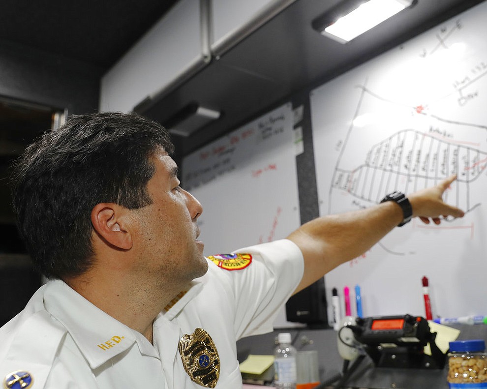 CORRECTS SPELLING FROM LELANI TO LEILANI -Hawaii Fire Department battalion chief Darwin Okinaka points to a map where recent volcanic eruptions have occurred on Friday, May 4, 2018, at Leilani Estates in Pahoa, Hawaii. Civil defense has set up a command center at the entrance to the subdivision, and authorities have ordered a mandatory evacuation. (AP Photo/Marco Garcia)