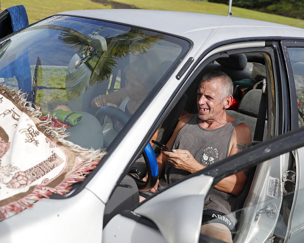 Mary Hicks, 56, left, and Tim Hicks, 51, both residents of the Leilani Estates, spent the night in their car after being evacuated from their home due to a lava eruption, Friday, May 4, 2018, in Pahoa, HI. (AP Photo/Marco Garcia)