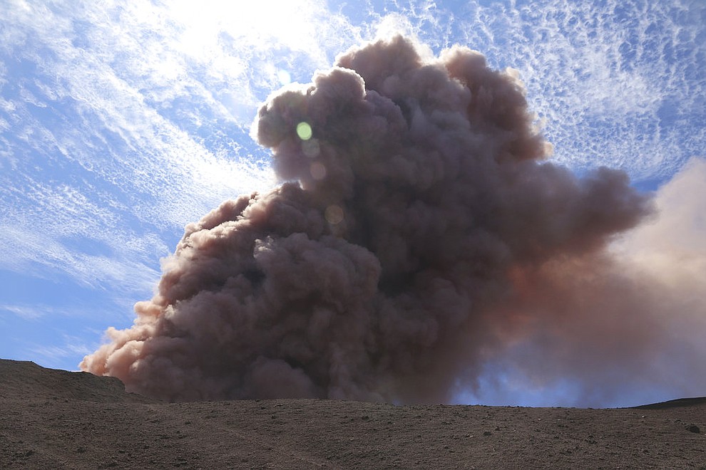 In this photo released by U.S. Geological Survey, a plume of ash rises from the Puu Oo vent on Hawaii's Kilaueaa Volcano after a magnitude 5.0 earthquake, Thursday, May 3, 2018 in Hawaii Volcanoes National Park. Hawaii's Kilauea volcano erupted Thursday, sending lava shooting into the air in a residential neighborhood and prompting mandatory evacuation orders for nearby homes. Hawaii County said steam and lava poured out of a crack in Leilani Estates, which is near the town of Pahoa on the Big Island. (U.S. Geological Survey)