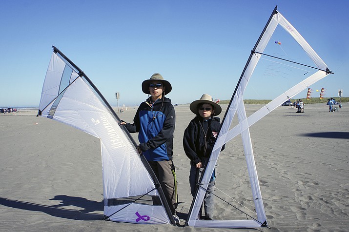 In this August 27, 2017 photo provided by P.V. Nguyen, Dylan Nguyen, left, and Cardin Nguyen are shown holding their kites and enjoy flying and competing at the Washington State International Kite Festival in Long Beach, Wash. (P.V. Nguyen via AP)

