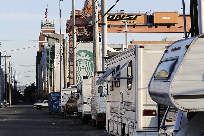In this May 7, 2018 photo, recreational vehicles used for shelter by people lacking traditional housing are parked near Starbucks’ Seattle headquarters. Seattle’s latest tax proposal to combat homelessness takes aim at large businesses, such as Starbucks and Amazon, that have helped drive the city’s economic boom. But businesses and others say the so-called head tax is misguided and potentially harmful. (Ted S. Warren/AP)