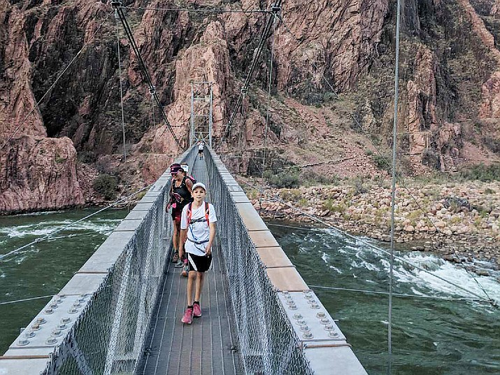 Talen Pitterle of Dewey, 11, crosses the footbridge over the Colorado River on his one-day trek from rim-to-rim-to-rim of the Grand Canyon in April. He may be the youngest to accomplish the feat. (Courtesy)