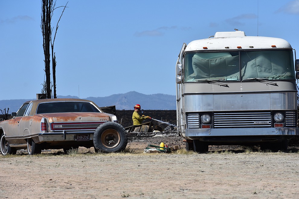 On the morning of May 12, 2018, a firefighter puts out hot spots on a home destroyed a day earlier by the Viewpoint Fire in the 7000 block of Whisper Ranch Road in the Poquito Valley community of Prescott Valley, Arizona. (Richard Haddad/WNI)