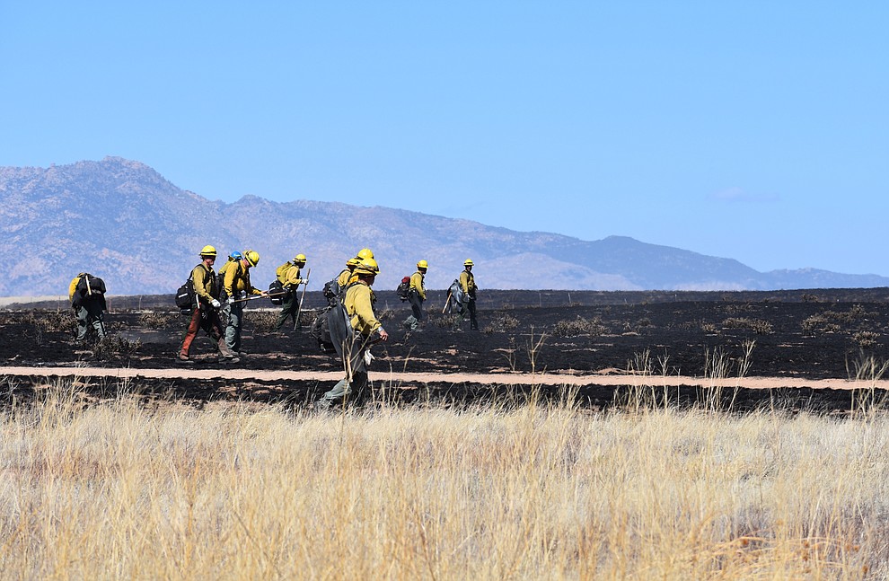 On the morning of May 12, 2018, fire crews walk in a line mopping up after the Viewpoint Fire in the Poquito Valley area of Prescott Valley, Arizona. (Richard Haddad/WNI)