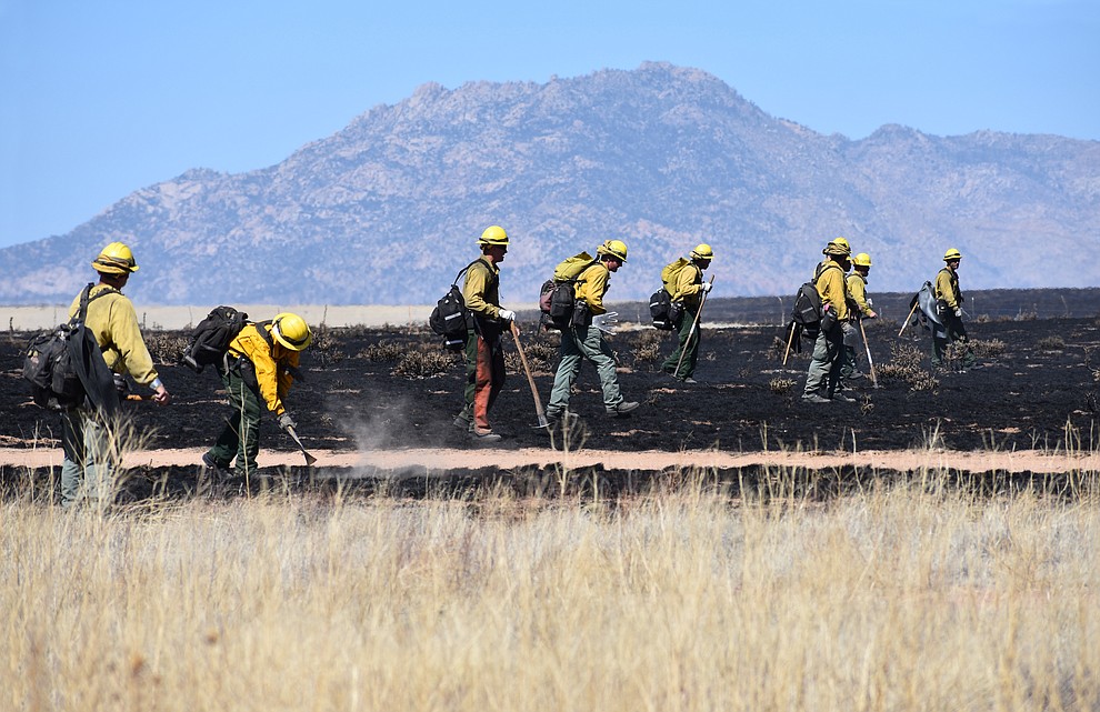 On the morning of May 12, 2018, fire crews walk in a line mopping up after the Viewpoint Fire in the Poquito Valley area of Prescott Valley, Arizona. (Richard Haddad/WNI)