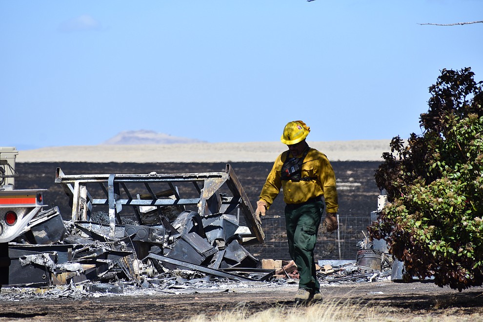 On the morning of May 12, 2018, a firefighter walks along the property line of a home that was destroyed by the Viewpoint Fire in the Poquito Valley community of Prescott Valley, Arizona. (Richard Haddad/WNI)