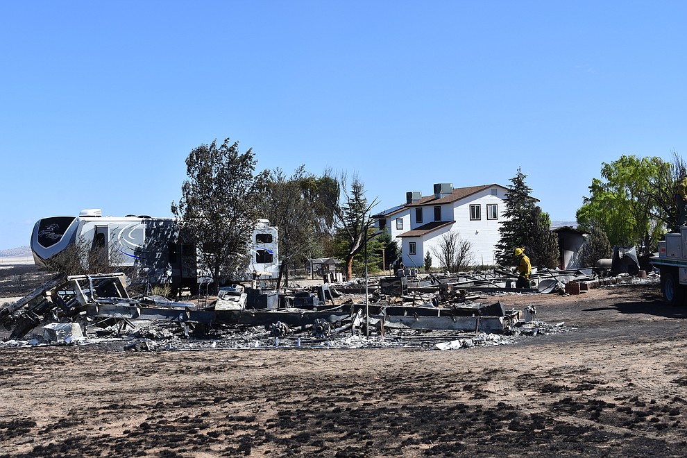 On the morning of May 12, 2018, a firefighter puts out hot spots on a home destroyed a day earlier by the Viewpoint Fire in the 7000 block of Whisper Ranch Road in the Poquito Valley community of Prescott Valley, Arizona. (Richard Haddad/WNI)