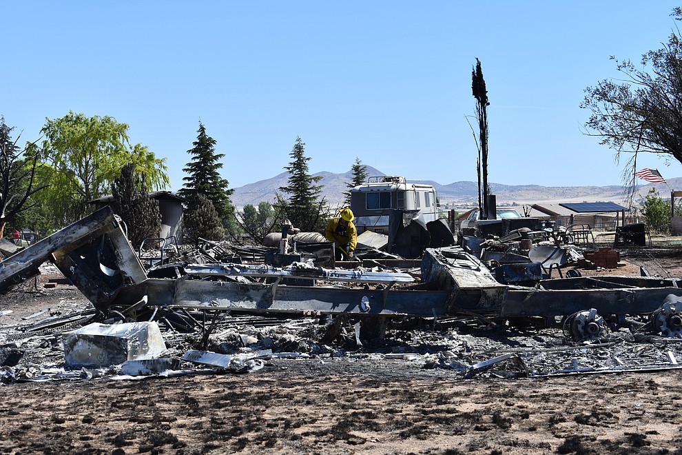 On the morning of May 12, 2018, a firefighter puts out hot spots on a home destroyed a day earlier by the Viewpoint Fire in the 7000 block of Whisper Ranch Road in the Poquito Valley community of Prescott Valley, Arizona. (Richard Haddad/WNI)