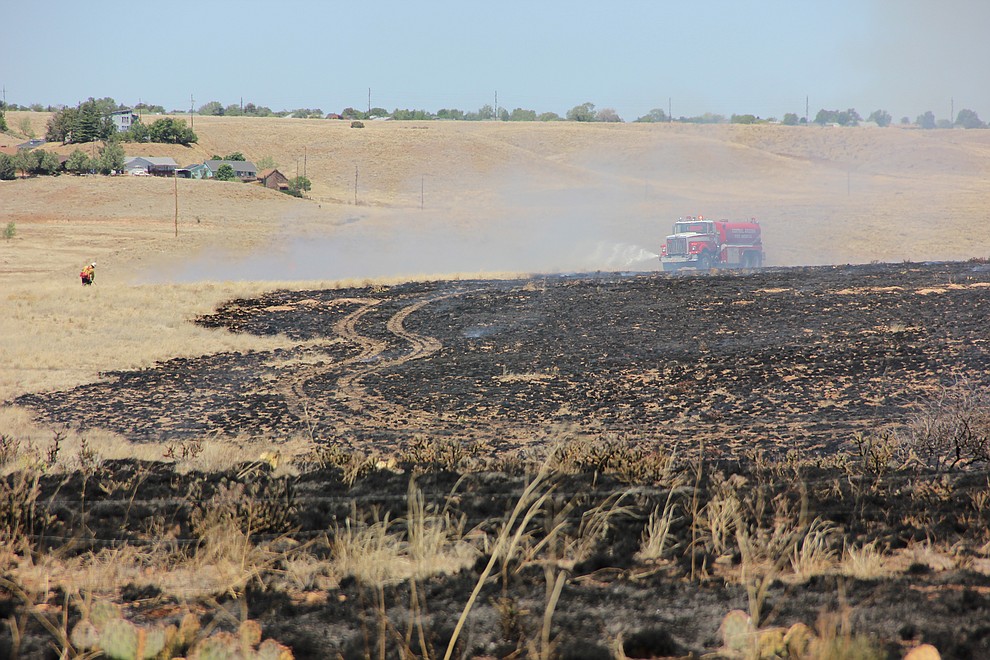 A Central Arizona Fire and Medical Authority vehicle sprays down the containment line surrounding a wildland fire that ripped through dry grassland just south of Fain Road in Prescott Valley on Monday, May 14, 2018.  (Max Efrein/Courier)