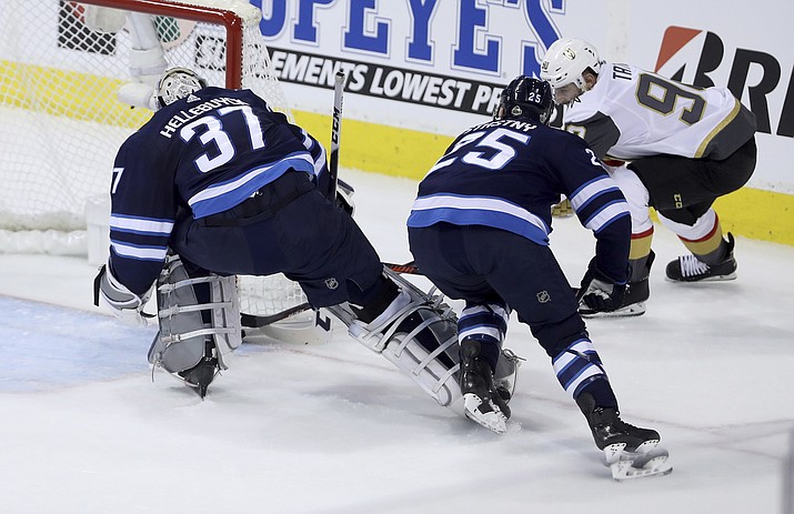 Las Vegas Golden Knights’ Tomas Tatar (90) scores on Winnipeg Jets goaltender Connor Hellebuyck (37) with Paul Stastny (25) in front of the net during first period game 2 NHL Western Conference Finals hockey action in Winnipeg, Manitoba, Monday, May 14, 2018. (Trevor Hagan/The Canadian Press via AP)
