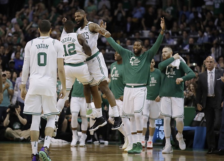 Boston Celtics guard Terry Rozier (12) and forward Marcus Morris leap in celebration near the end of Game 2 of the team's NBA basketball Eastern Conference finals against the Cleveland Cavaliers, Tuesday, May 15, 2018, in Boston. (AP Photo/Charles Krupa)